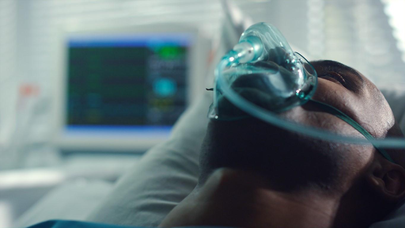 Supine patient wearing oxygen mask