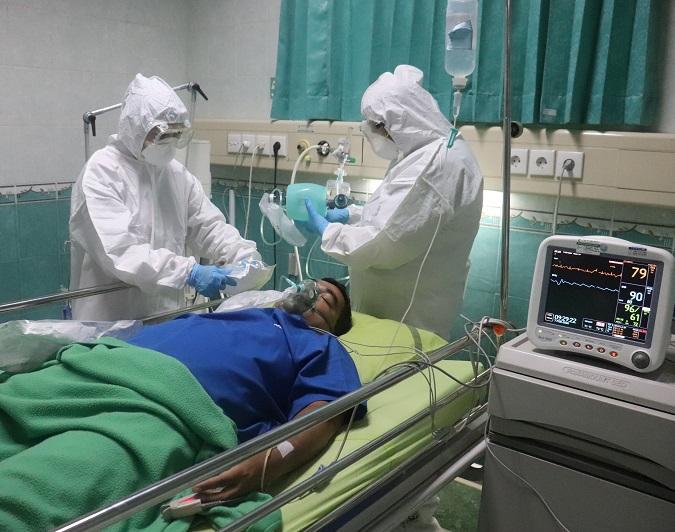 Nurses giving oxygen to ICU patient