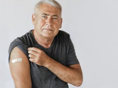 Older man with vaccine band-aid