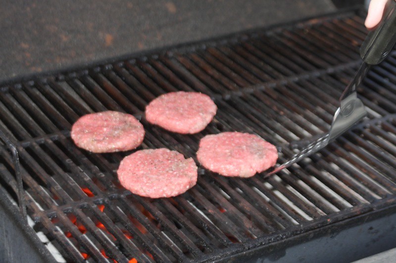 Raw burgers on grill