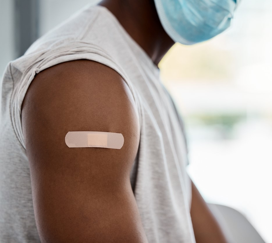 Man's arm with vaccine bandaid