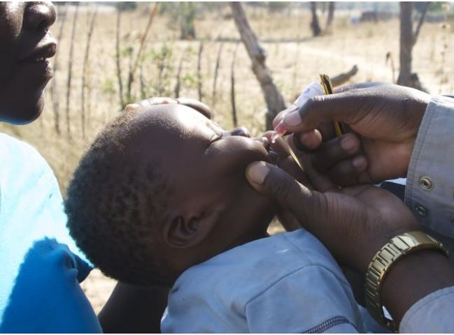 Young boy receiving oral polio vaccine