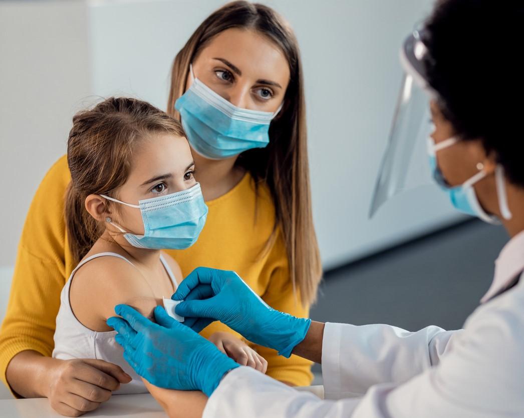 girl getting vaccine bandaid