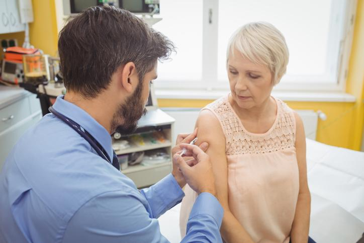 Nurse vaccinating older woman