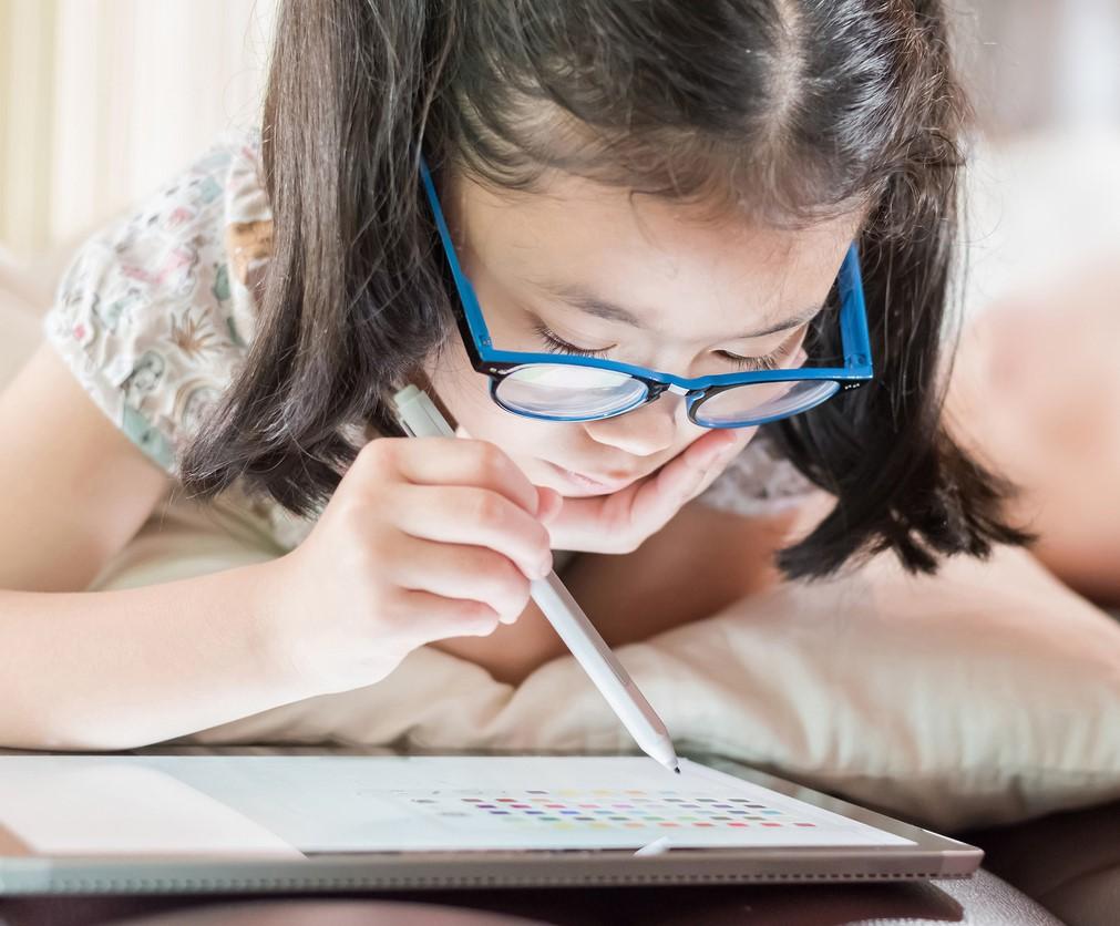 Girl with glasses using tablet device