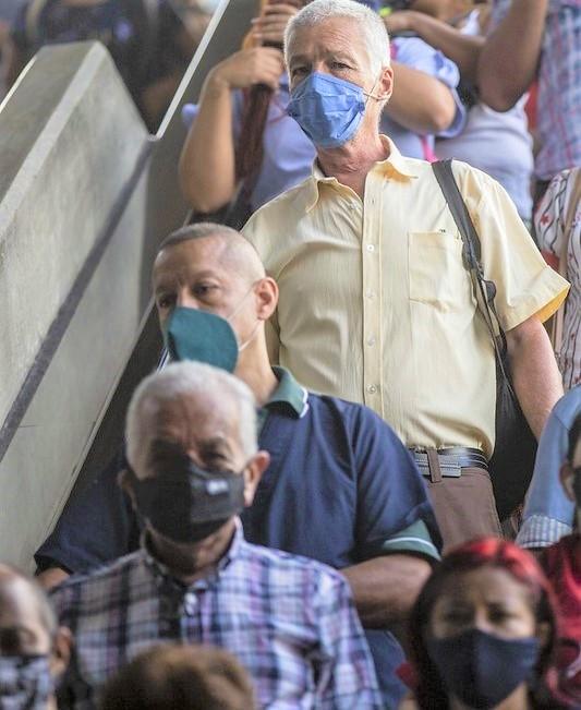 Train commuters inside station wearing masks