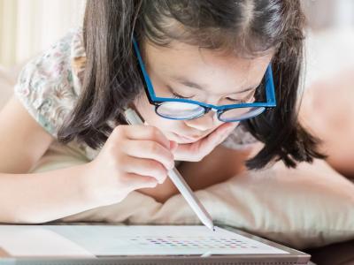 Girl with glasses using tablet device