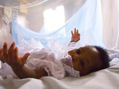 Infant under malaria bednet