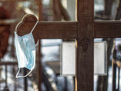 Surgical mask hanging from graveyard cross