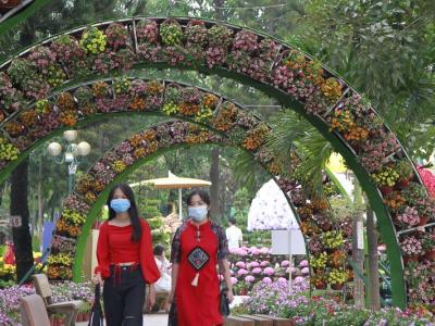 Masked women under flowered archways