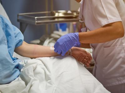 Nurse inserting catheter into arm
