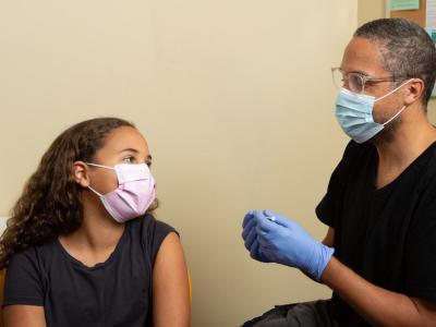 Young girl in mask getting vaccinated