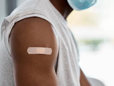 Mans arm with vax bandaid