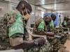 Ugandan soldiers helping with vaccinations