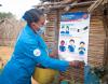Woman putting up COVID poster in Madagascar